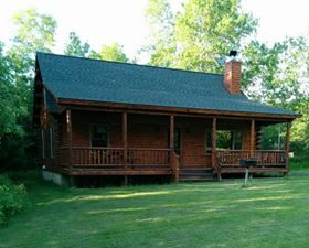 Rustic log cabin in Rangeley, Maine surrounded by trees and summer greenery, the lakeside vacation rental where I stayed during my 2017 moose‑spotting trip.