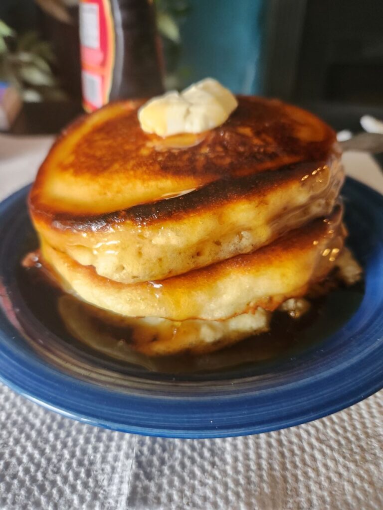 Hot and fluffy pamcakes swimming in butter and maple syrup to start the day