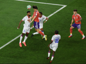 Players from Scotland and Haiti battle for possession in midair during their World Cup match.