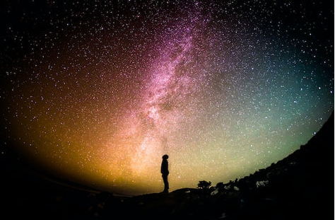 Sanding  in the light of the night sky enjoying the wonders of nature