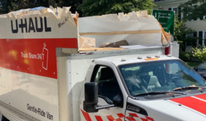 U‑Haul with its roof peeled back like a sardine can after striking a low bridge in Boston.