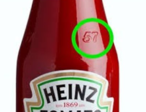   
A close-up of a Heinz ketchup glass bottle showing the embossed number “57” on the neck and part of the tomato ketchup label below