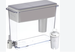 A clear Brita water dispenser with a gray lid sits beside a white cylindrical Brita filter cartridge on a light surface.
