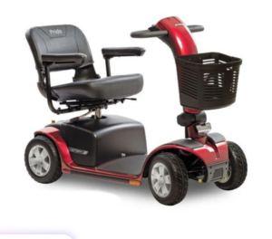 A red four‑wheel mobility scooter with a padded seat, armrests, handlebars, and a front basket, designed to help someone travel longer distances with comfort and support.