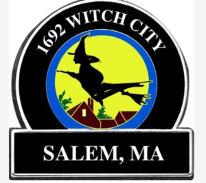  Circular “Witch City” emblem featuring a silhouette of a witch flying on a broomstick against a yellow background. Below her are red‑roofed buildings and green trees representing Salem, Massachusetts. The text “1692 WITCH CITY” appears at the top and “SALEM, MA” at the bottom.