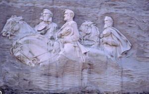   
High‑relief stone carving of three Confederate figures on horseback at Stone Mountain, Georgia, showing detailed sculpted horses and riders against the rock face.